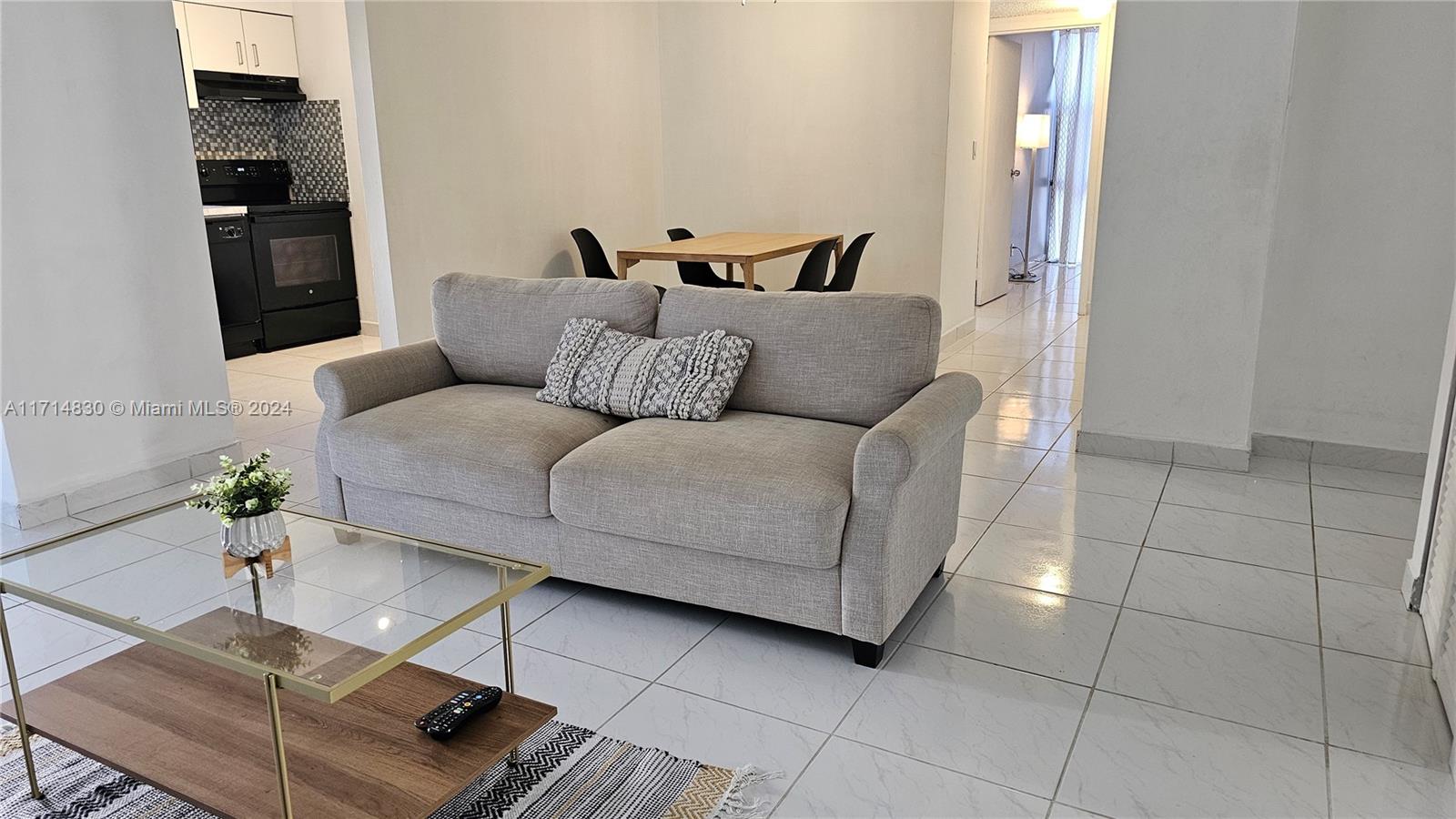 a living room with furniture and a potted plant