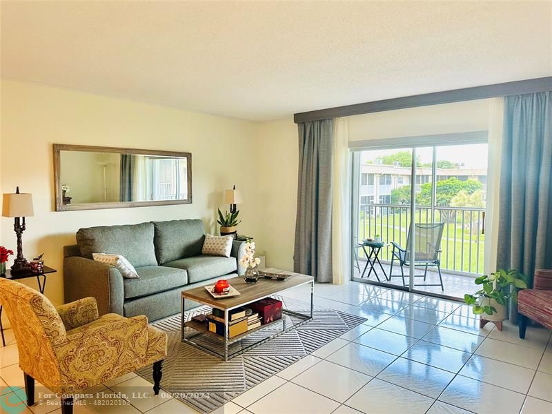 a living room with furniture and a floor to ceiling window