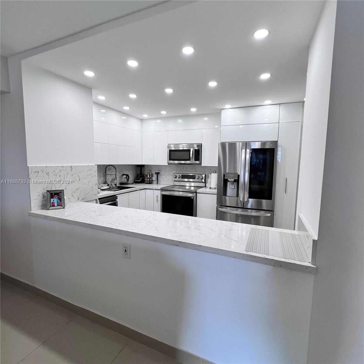 a large kitchen with kitchen island a sink stainless steel appliances and cabinets