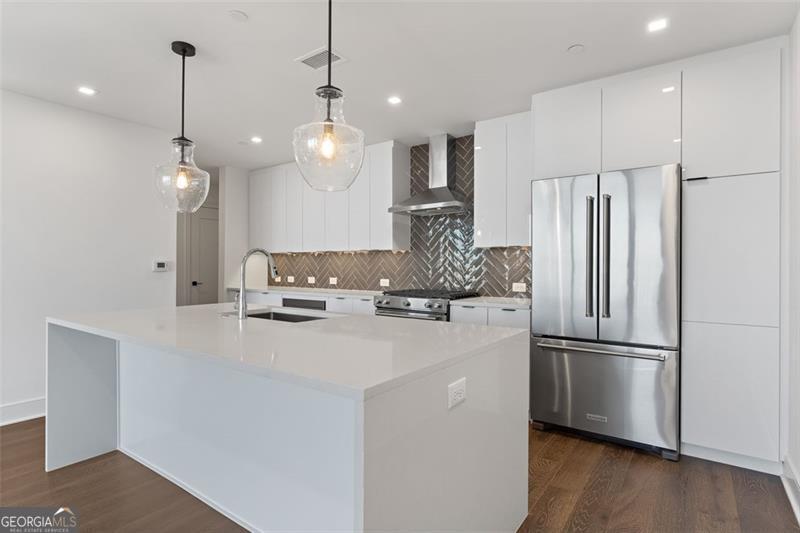 a kitchen with kitchen island white cabinets and stainless steel appliances