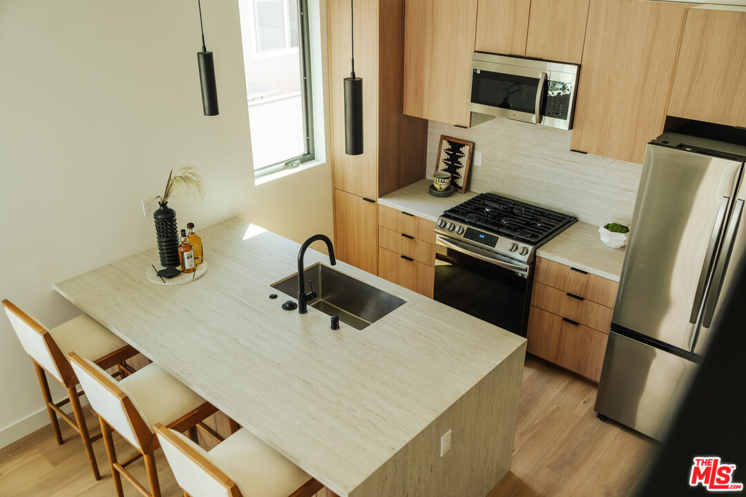 a kitchen with sink a microwave and refrigerator