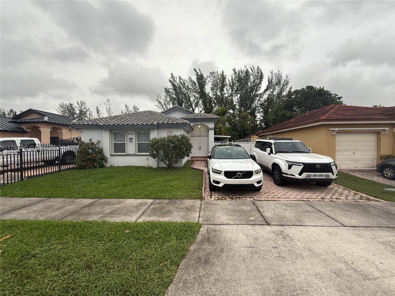 a couple of cars parked in front of a house