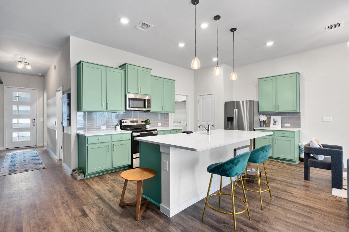 a kitchen with cabinets a table and chairs in it