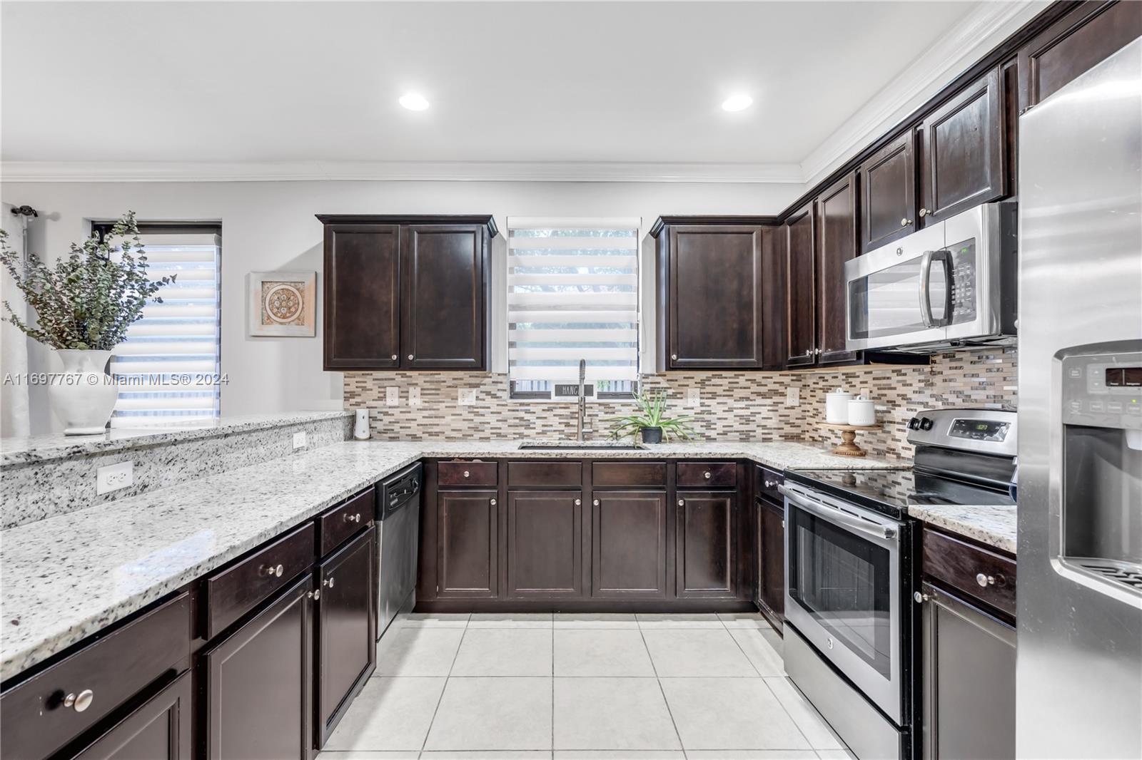 a kitchen with stainless steel appliances granite countertop a sink stove and cabinets