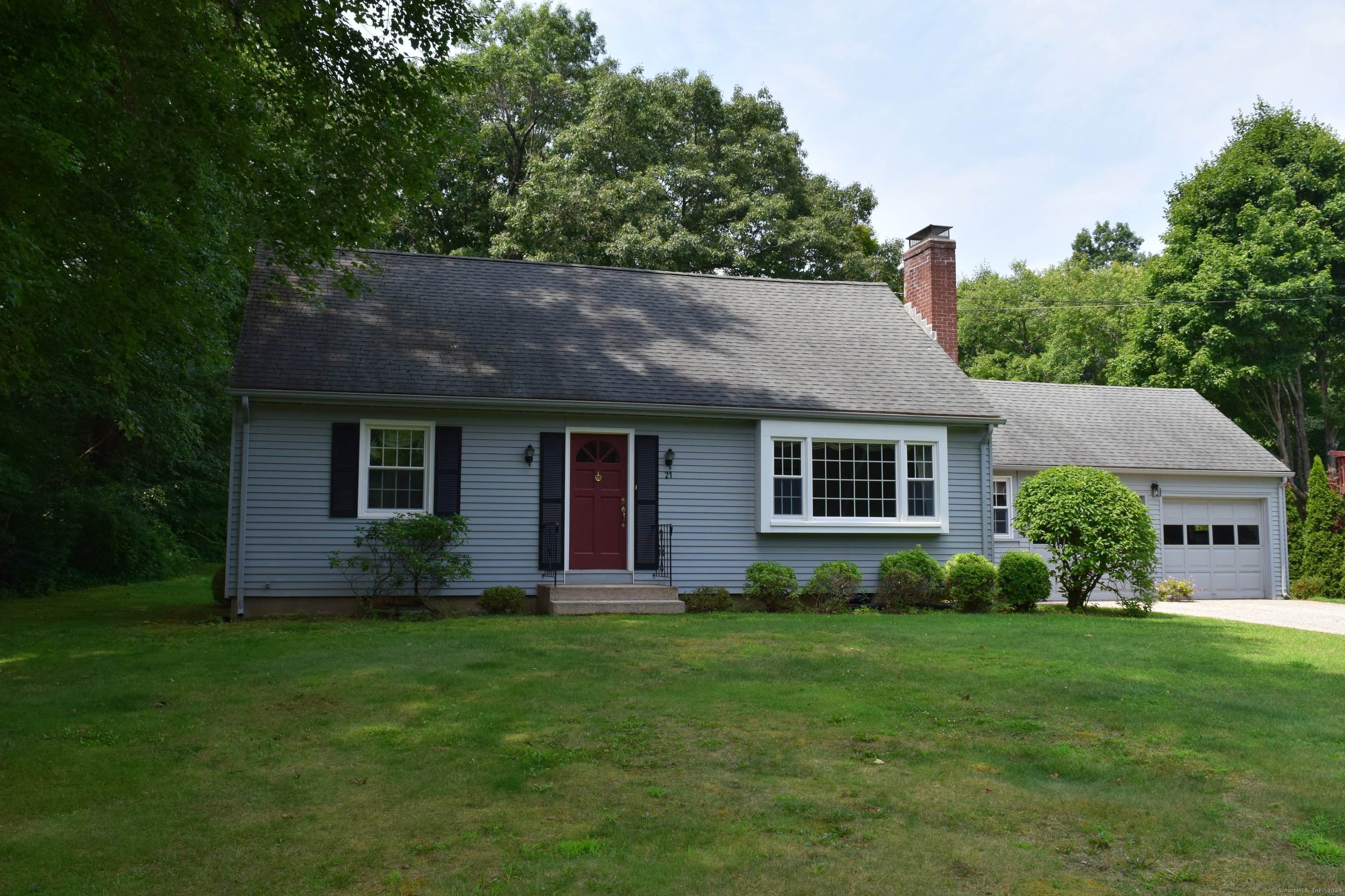 a front view of house with a garden and yard