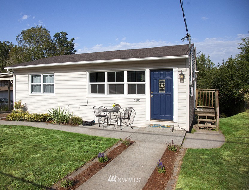 a view of house with backyard and outdoor seating