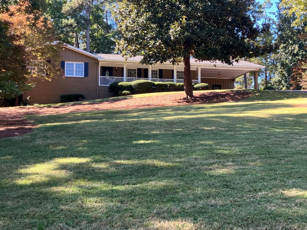 a view of a house with a backyard and a patio