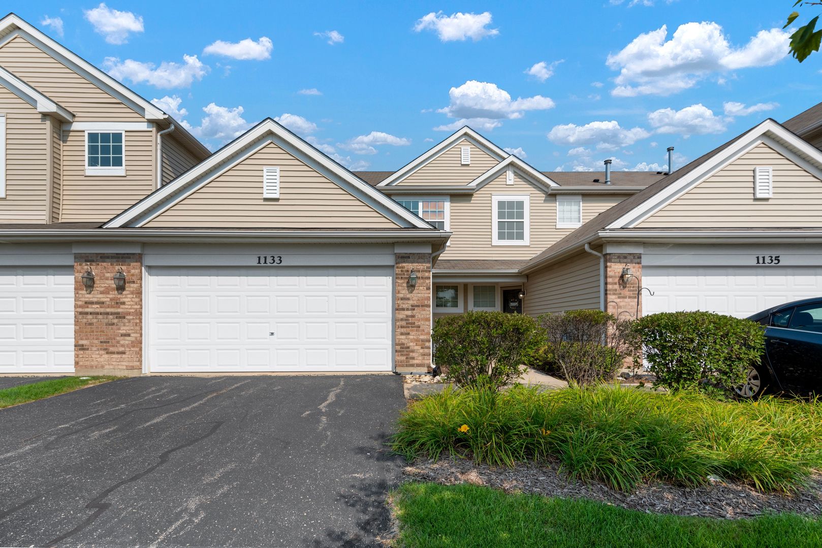 a front view of a house with a yard and garage