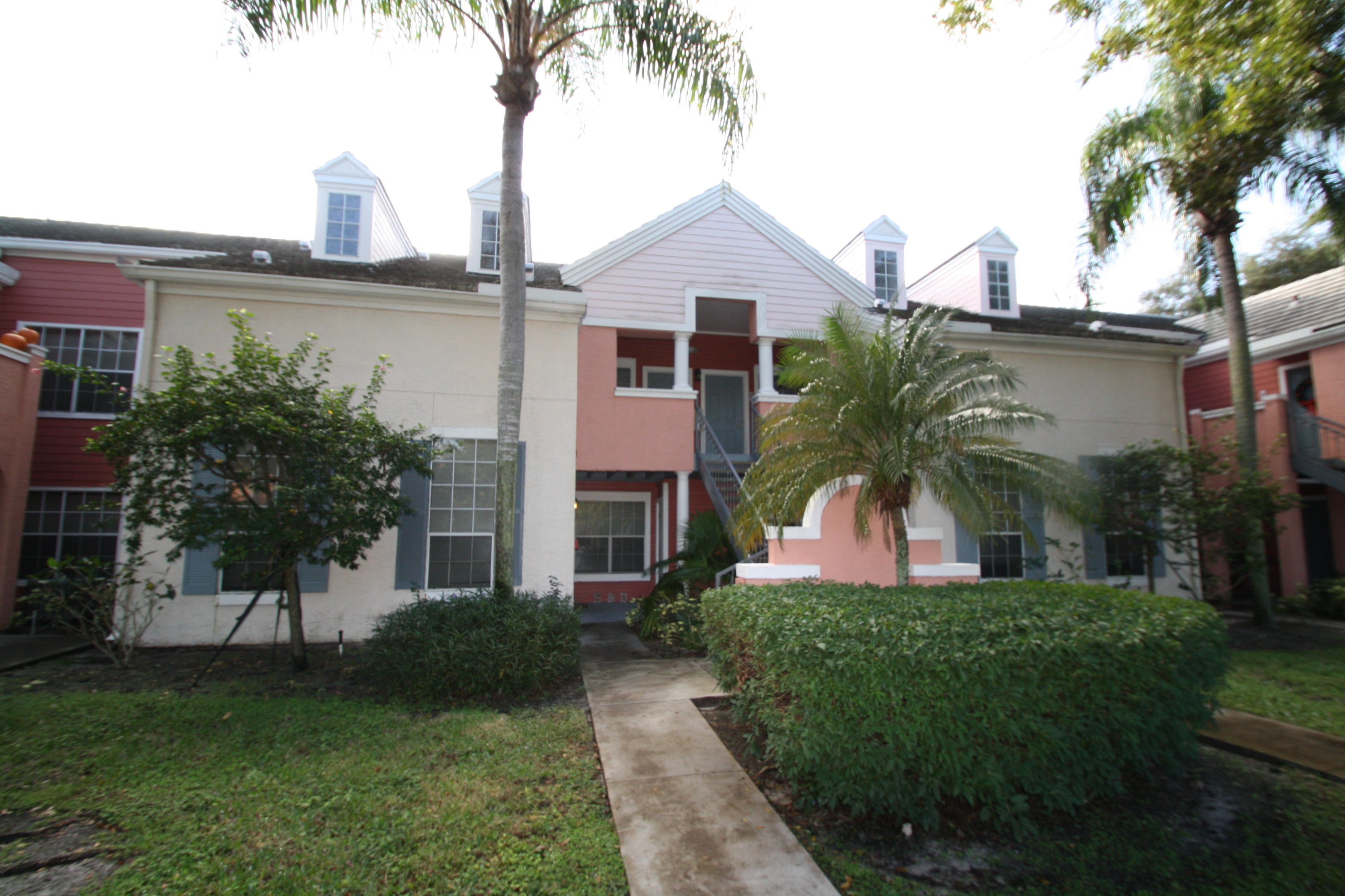 a front view of a house with a garden and plants