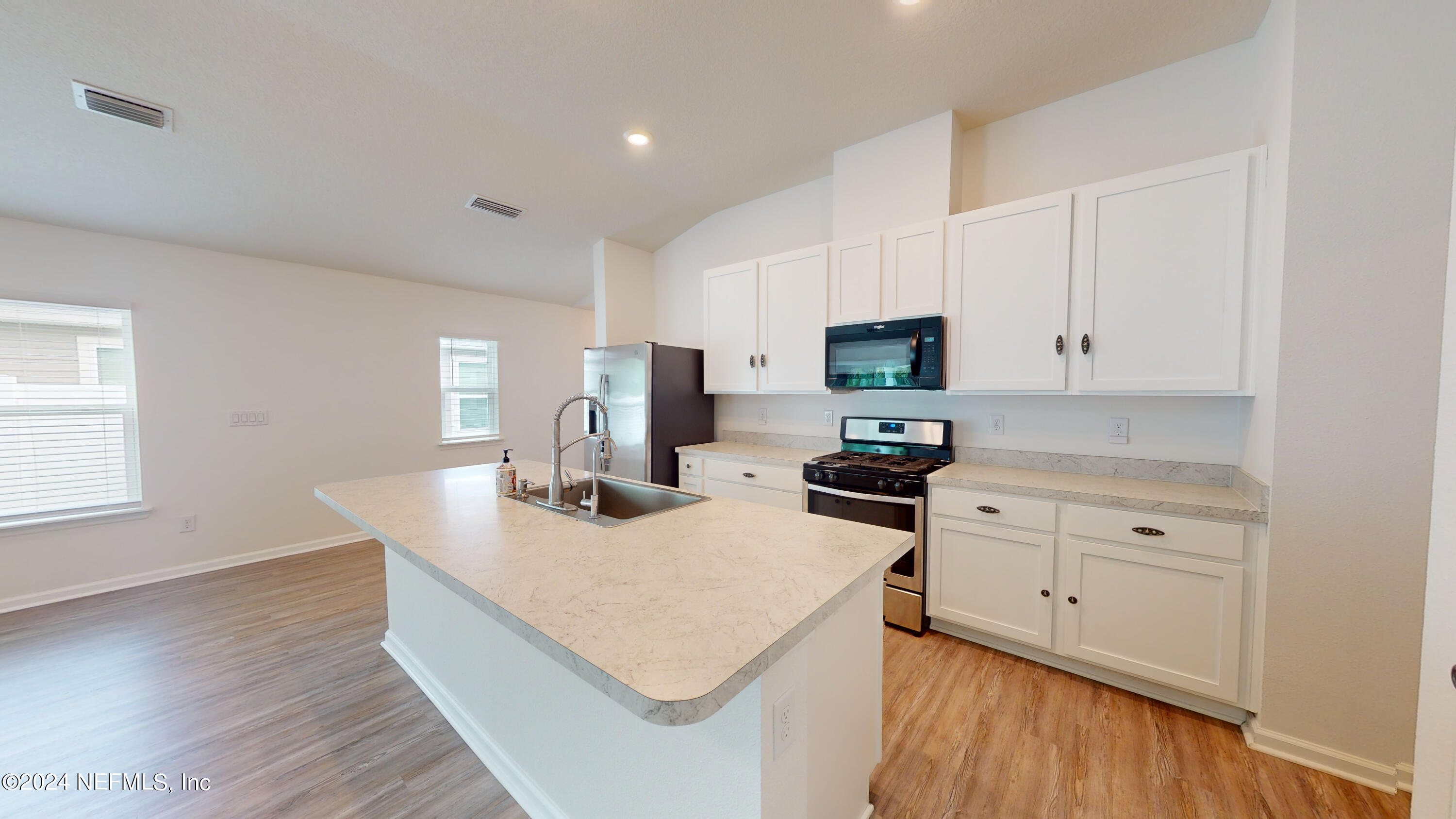 a kitchen with a stove a sink and a refrigerator