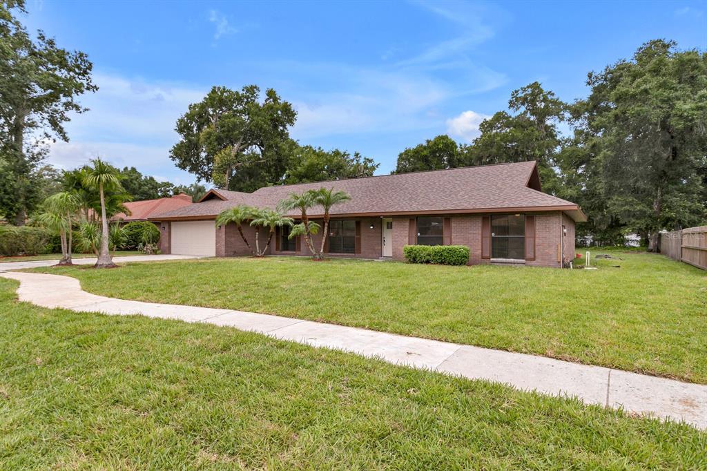 a front view of a house with a yard and trees