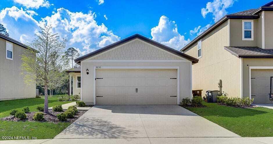 a view of a house with a yard and garage