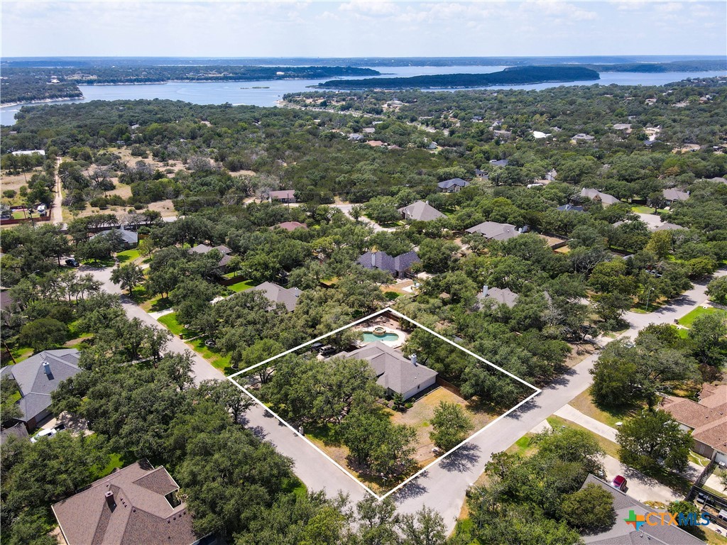 an aerial view of residential houses with outdoor space and trees