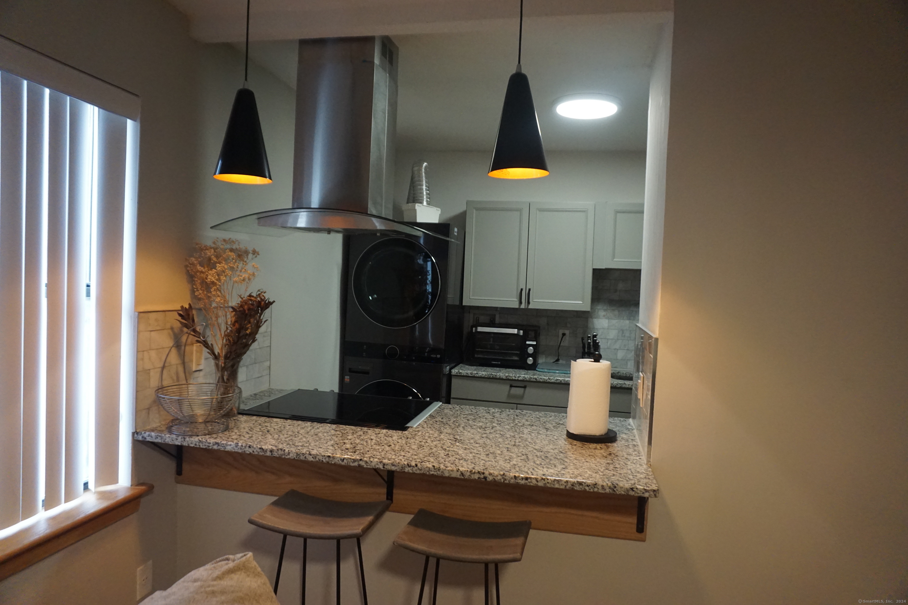 a kitchen with a sink and a stove with chairs