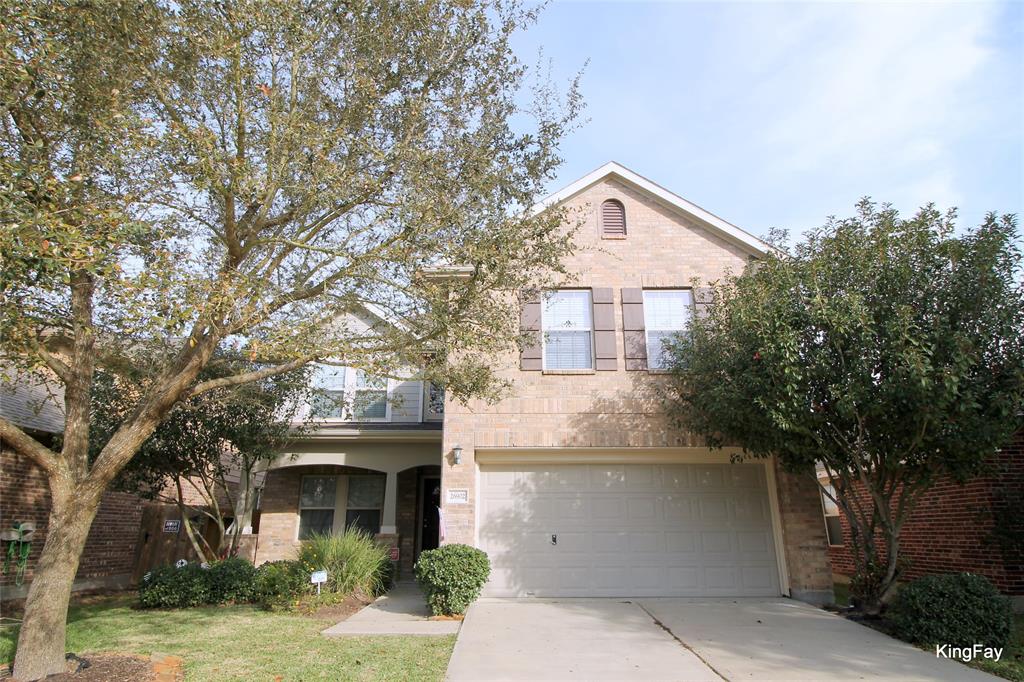 a front view of a house with yard and tree