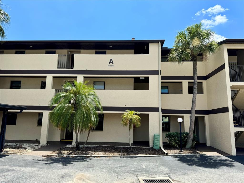 a front view of a building with palm trees