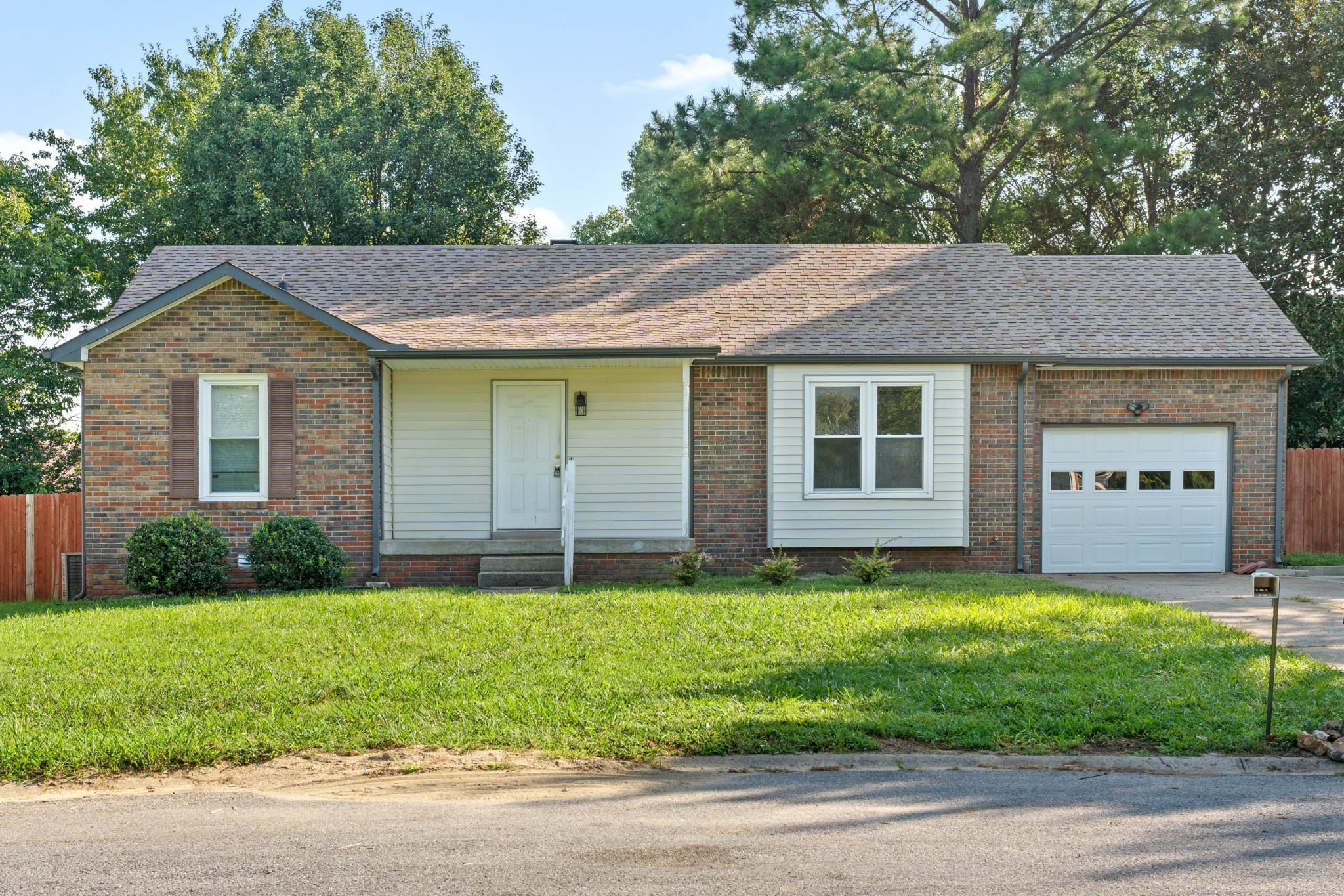 a view of a house with a yard and large tree