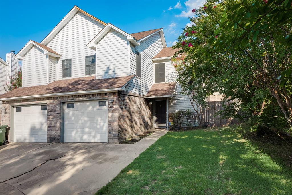 a view of a house with a yard and a garage