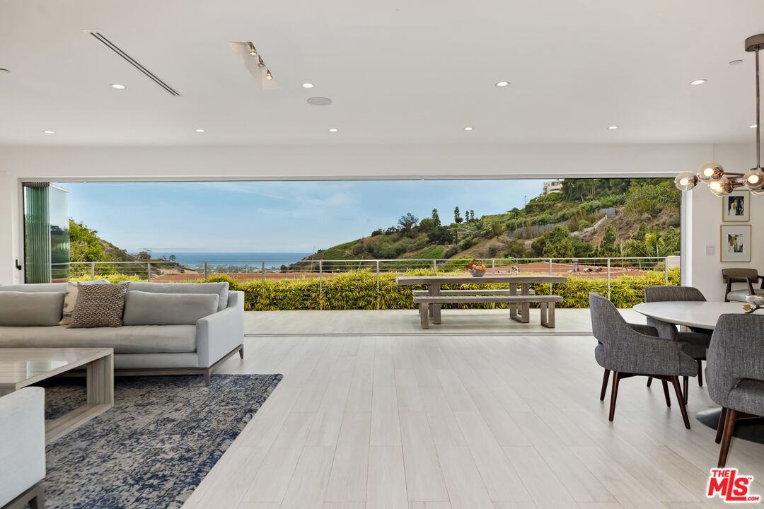 a living room with furniture and a floor to ceiling window