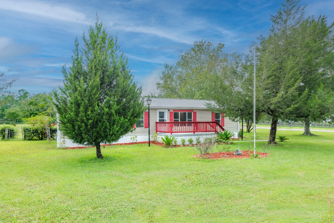 a view of a house with a yard and tree s