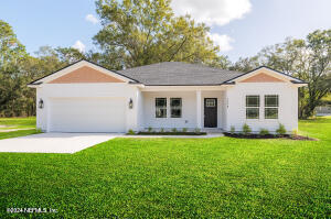 a front view of a house with a garden and yard