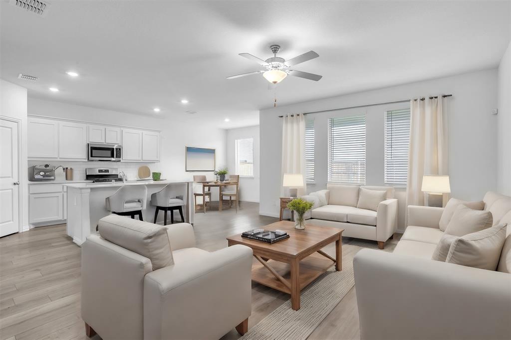 a living room with furniture kitchen and a large window