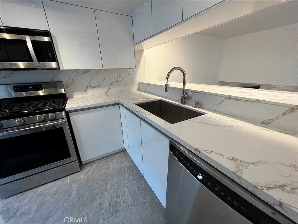 a kitchen with a sink and stainless steel appliances