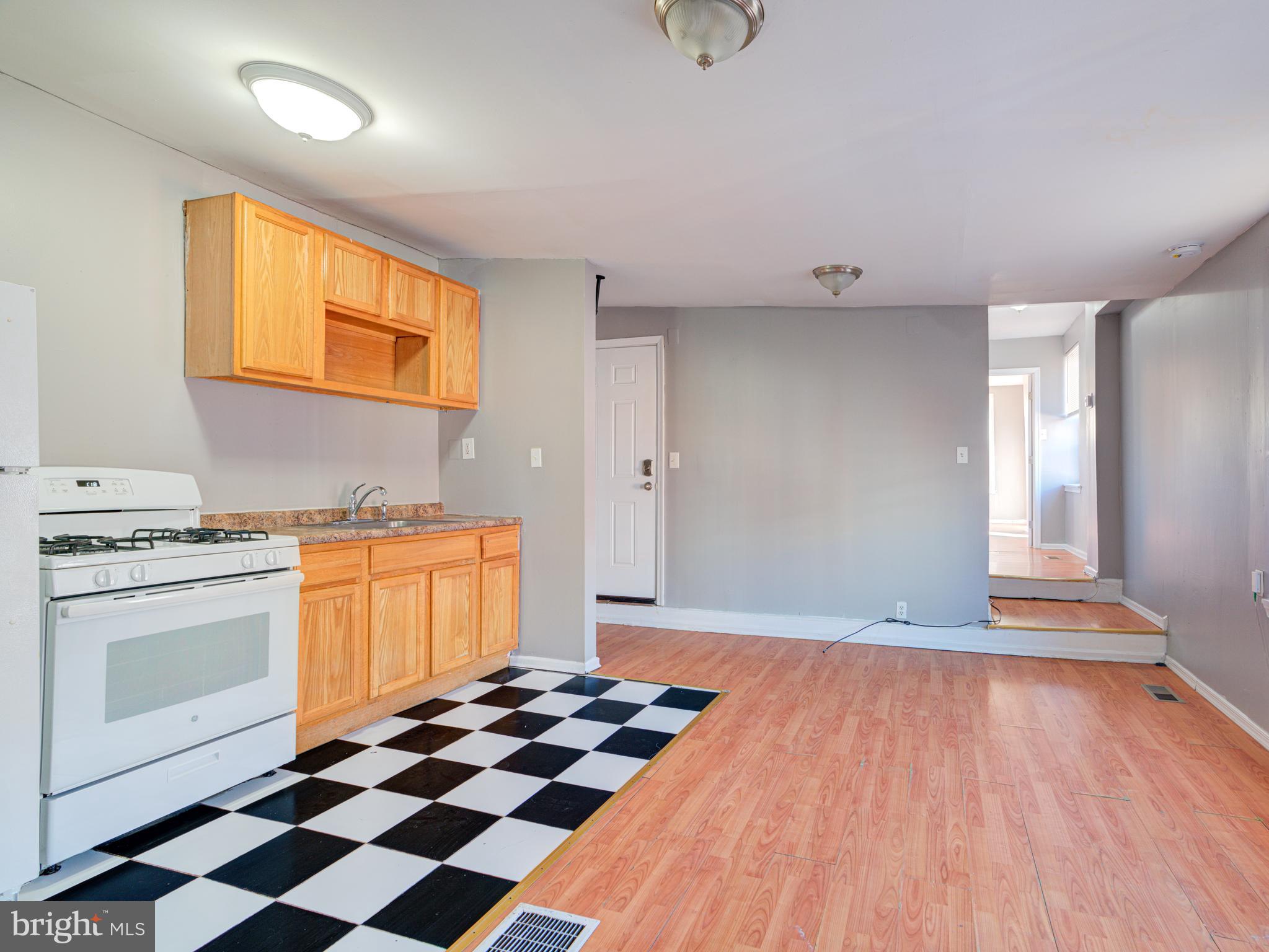 a kitchen with granite countertop stainless steel appliances a stove and a wooden floor