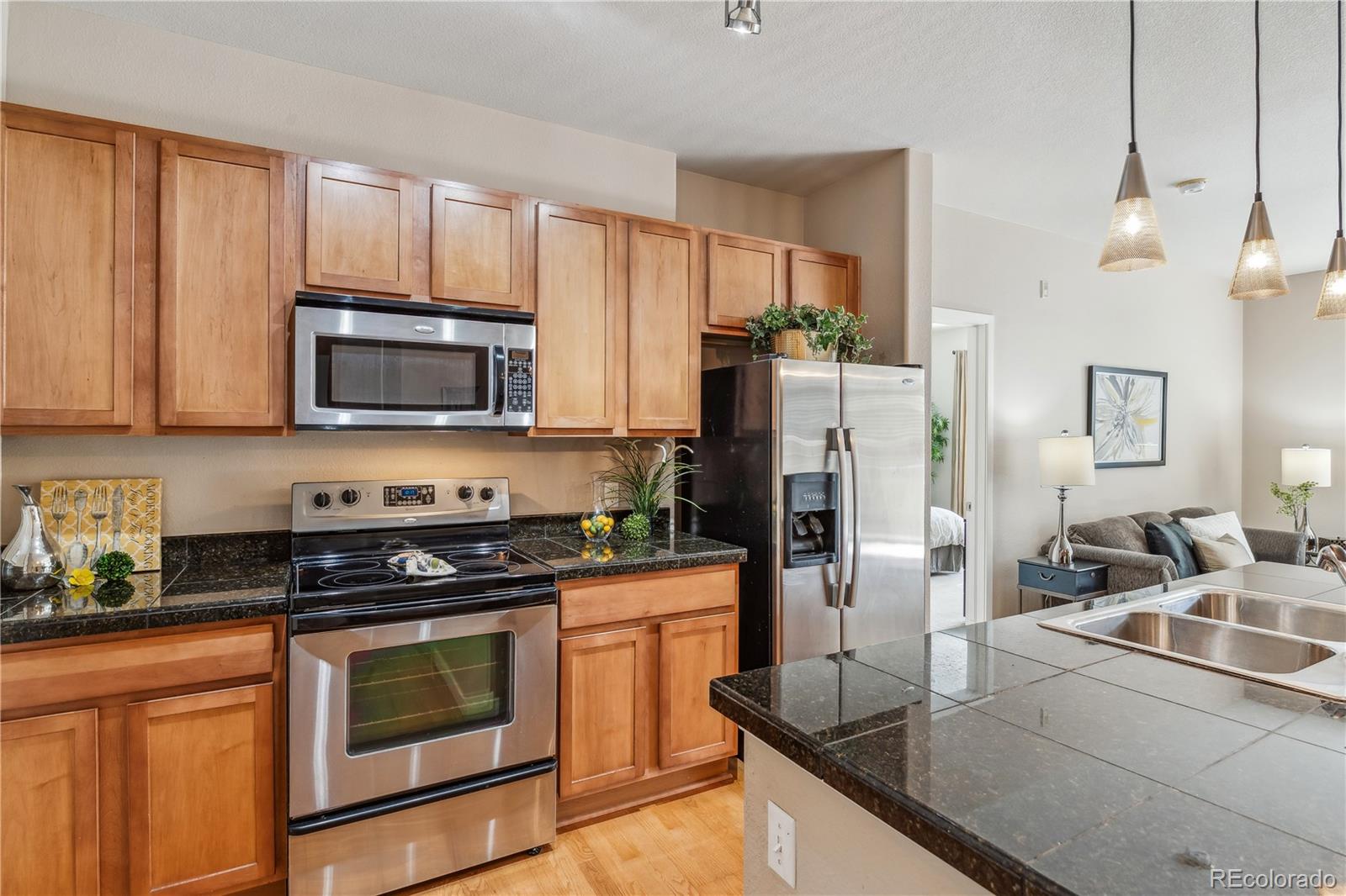 a kitchen with granite countertop a refrigerator stove and microwave