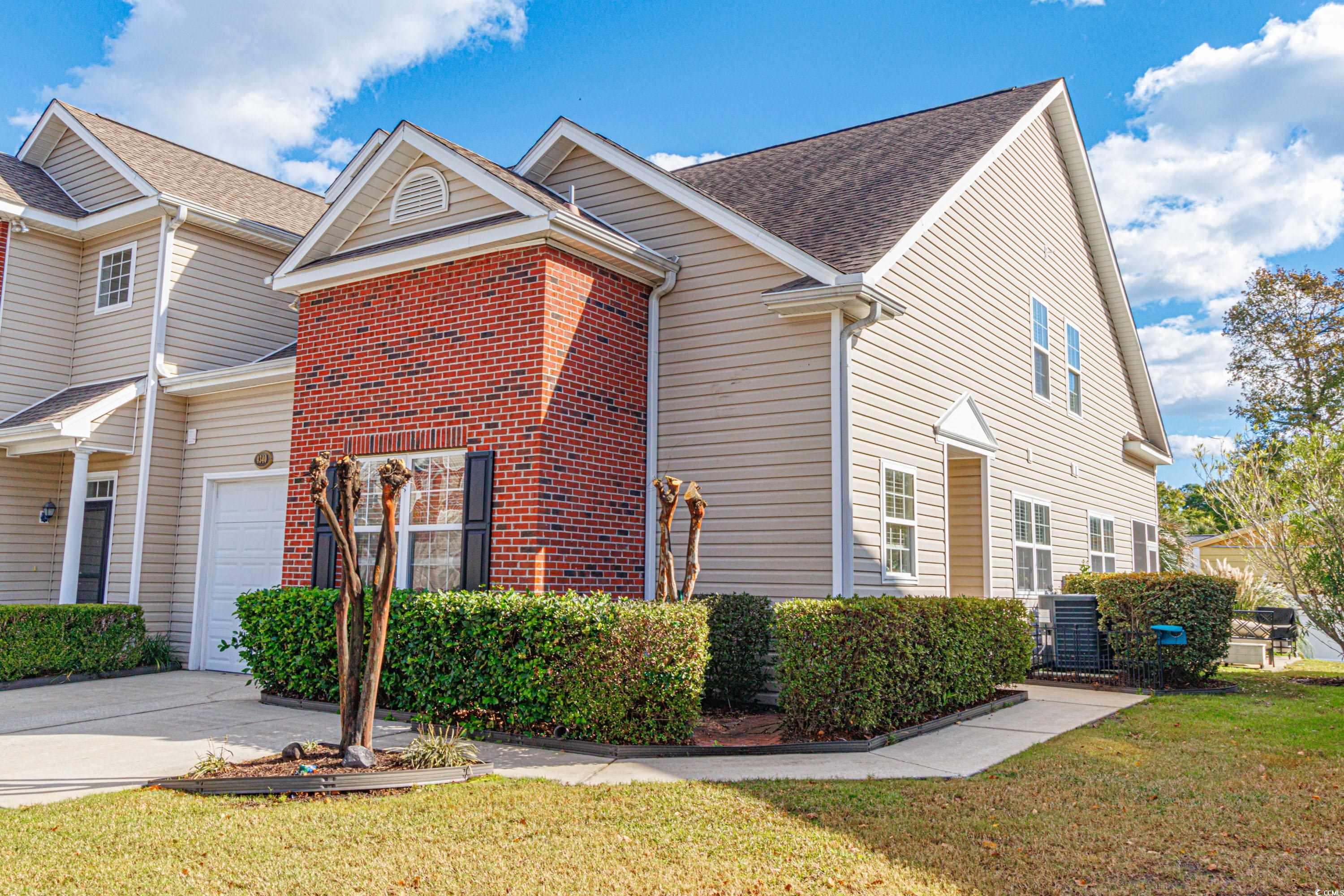 View of home's exterior with a lawn and a garage