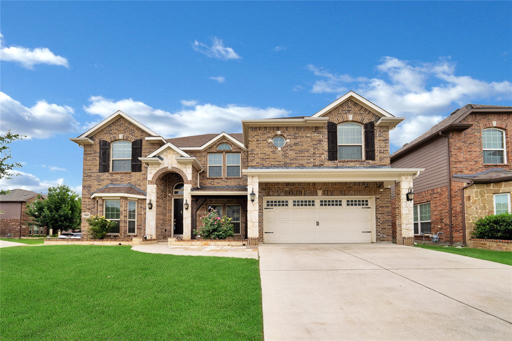 a front view of a house with a yard and garage