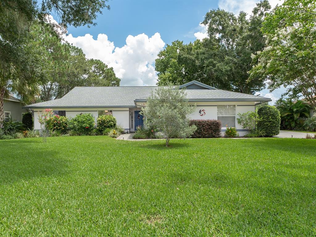 a front view of a house with a yard and trees