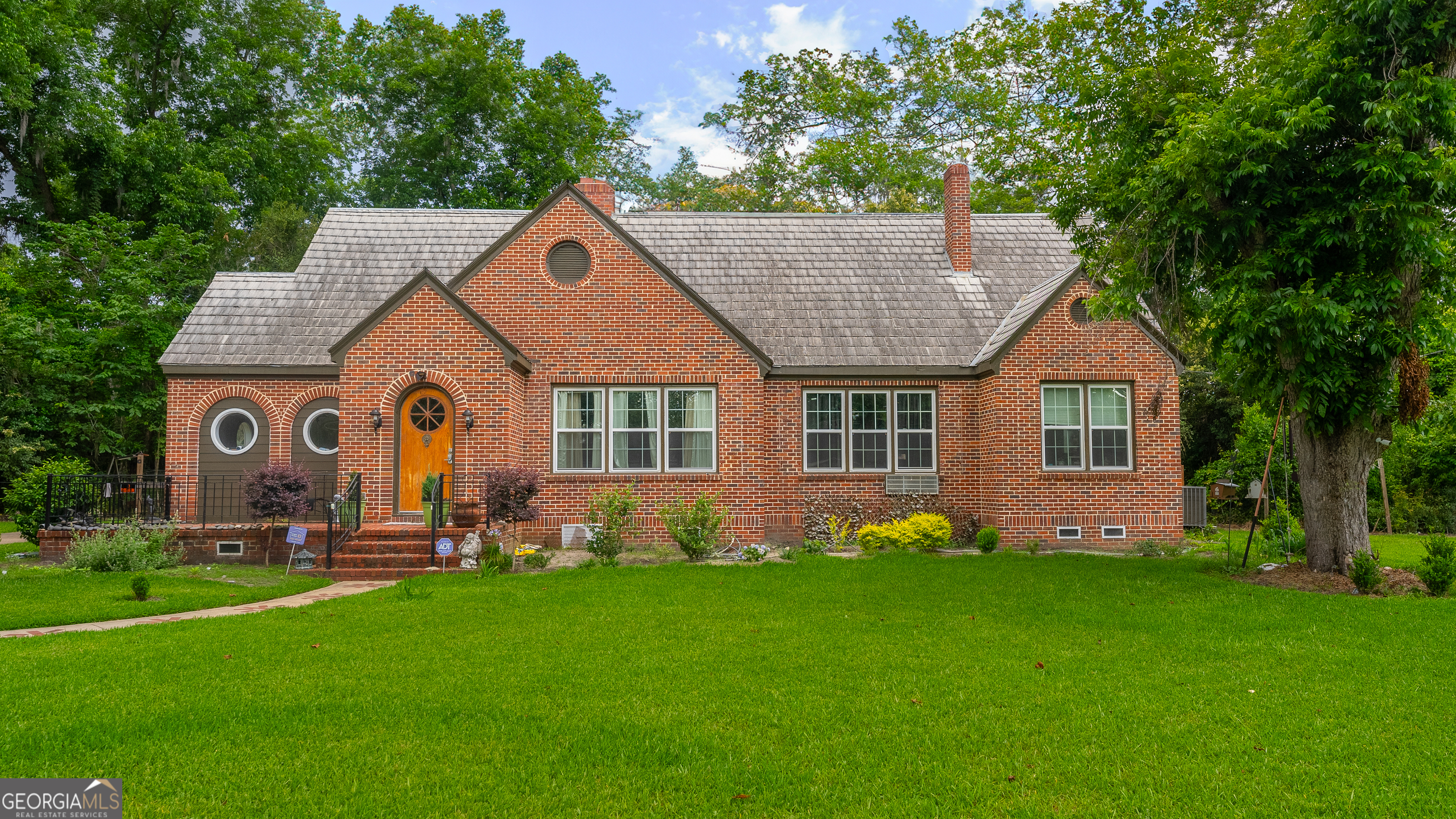 a front view of house with yard and green space