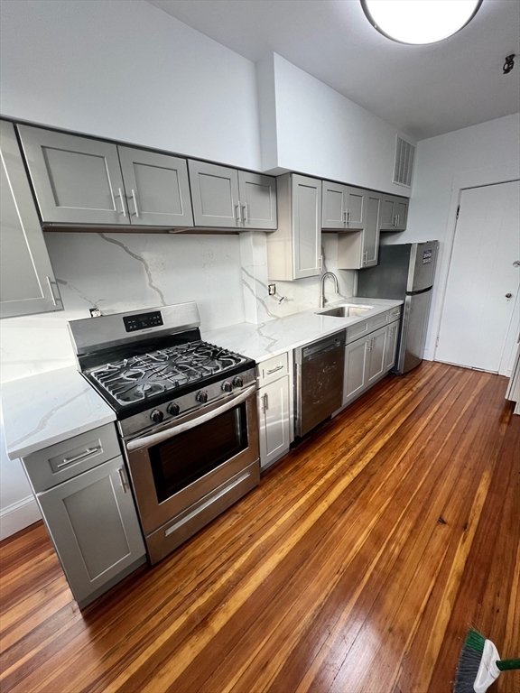 a kitchen with stainless steel appliances granite countertop a stove and a sink