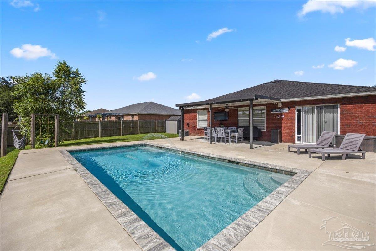 a view of a house with swimming pool and sitting area