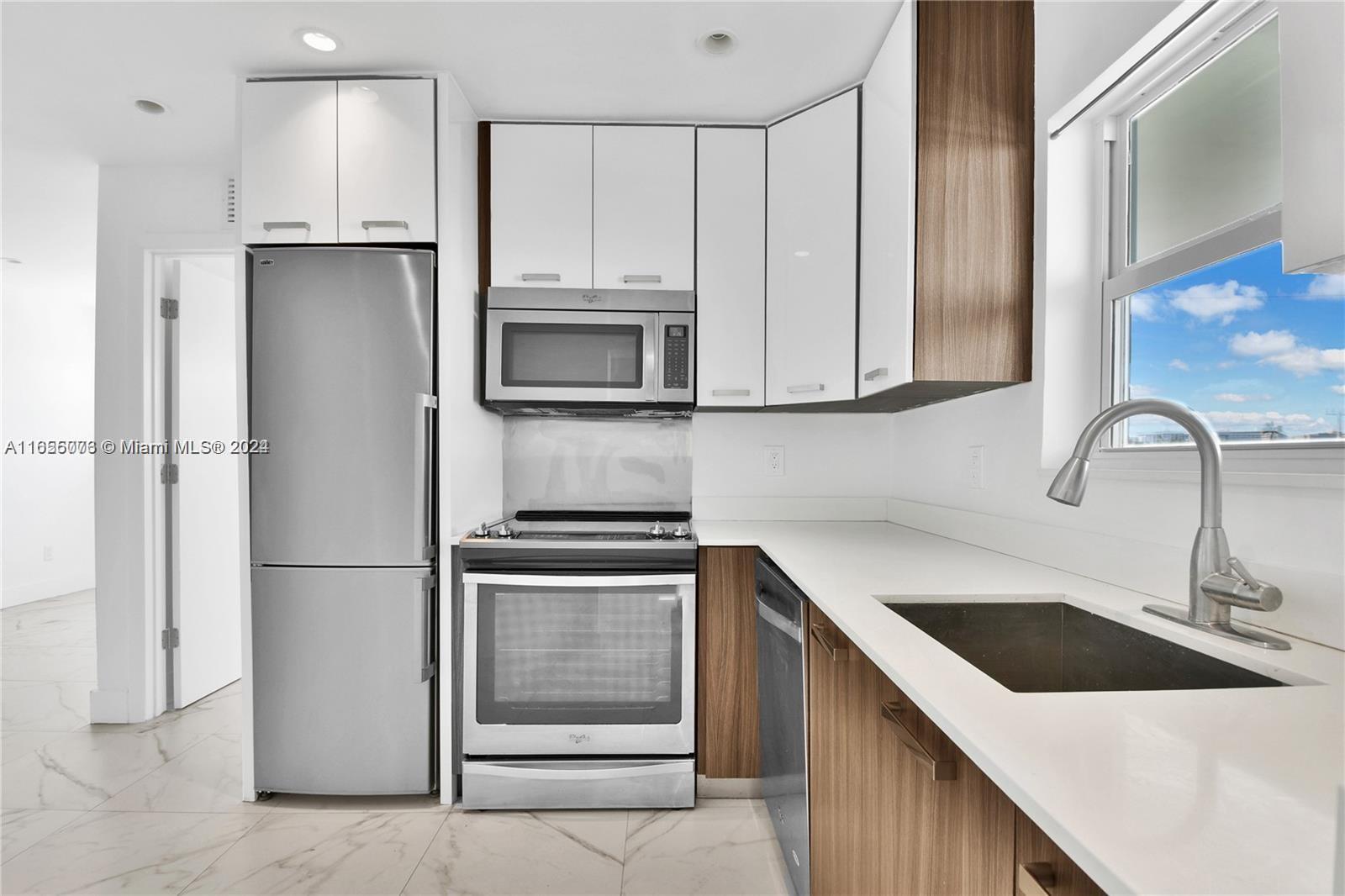 a kitchen with a sink a refrigerator and cabinets