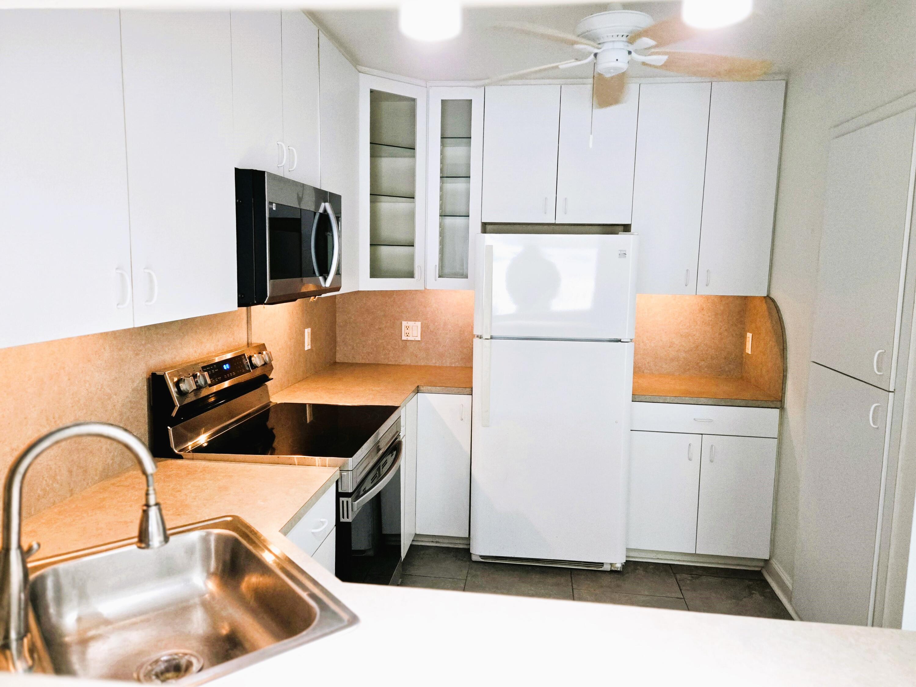 a kitchen with a refrigerator sink and cabinets