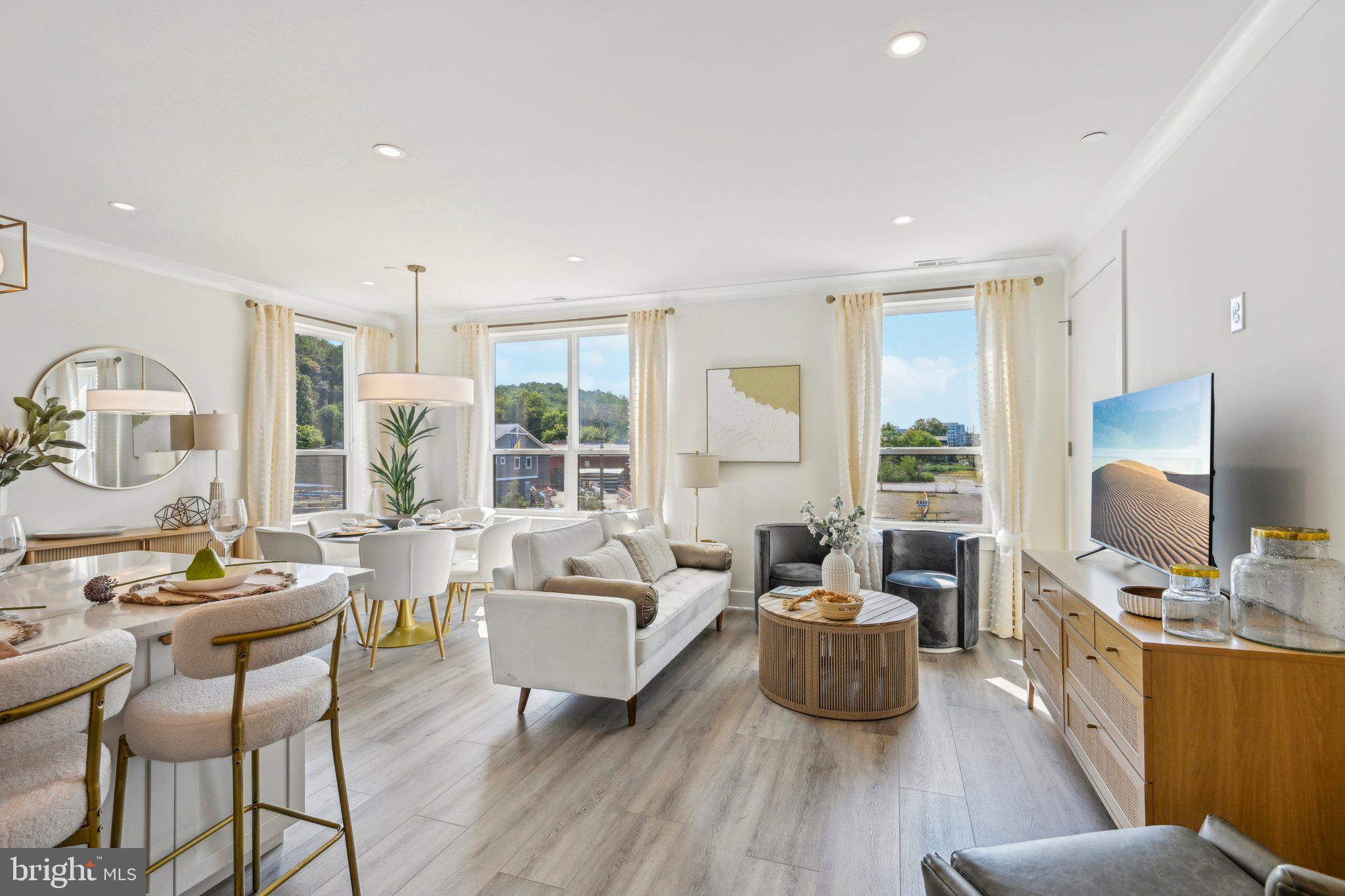 a living room with furniture flat screen tv and large window