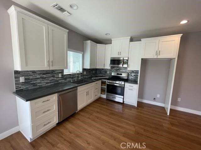 a kitchen with granite countertop a refrigerator and a stove top oven