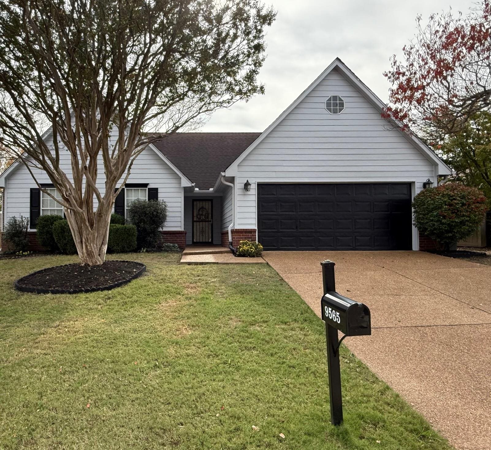 Ranch-style home featuring a garage and a front lawn