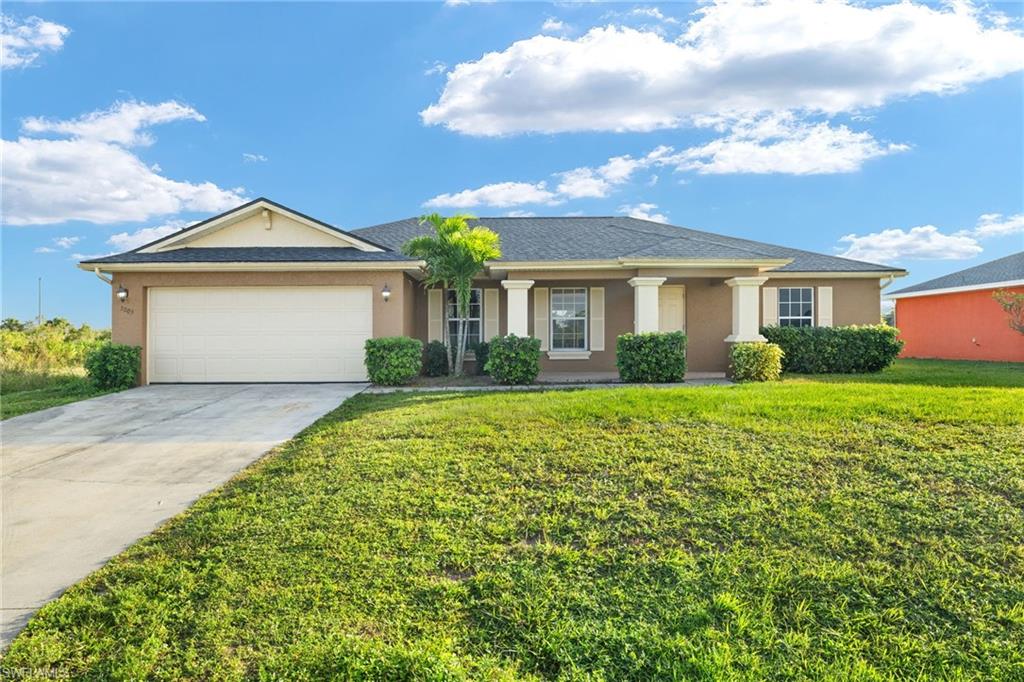 Ranch-style home with a front yard and a garage