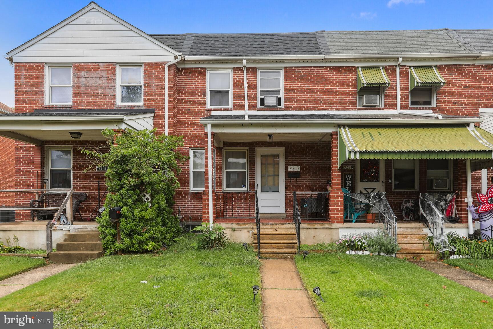 front view of a brick house with a yard