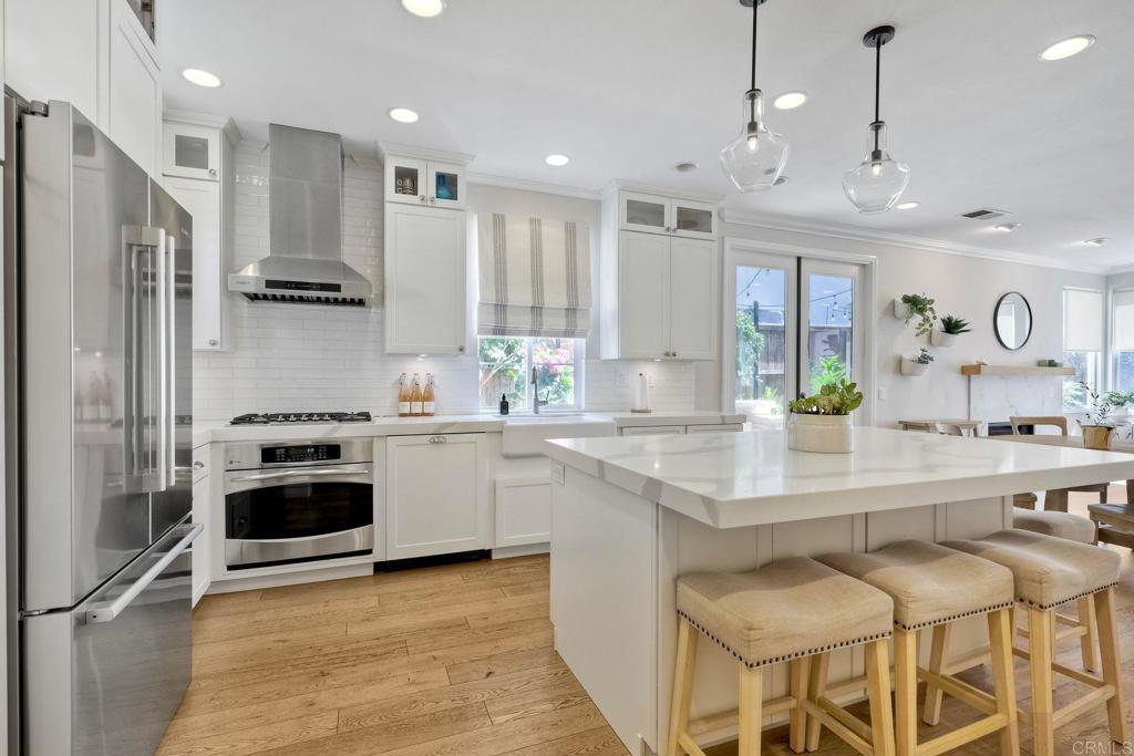 a kitchen with stainless steel appliances granite countertop a stove a sink and a refrigerator