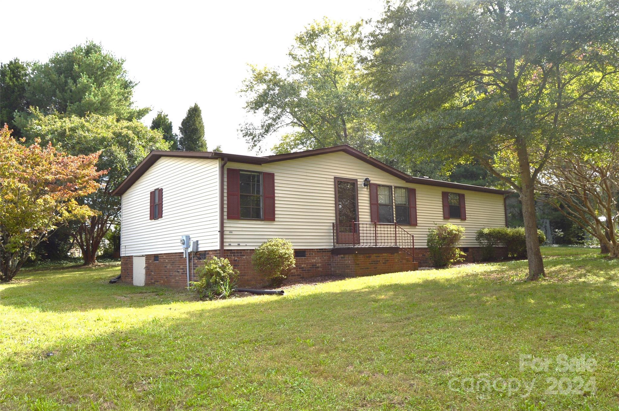 a view of a yard with a house and a large tree