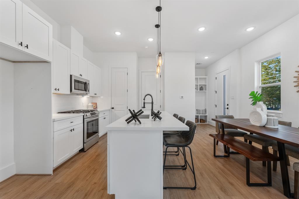 a kitchen with stainless steel appliances kitchen island granite countertop a sink and refrigerator