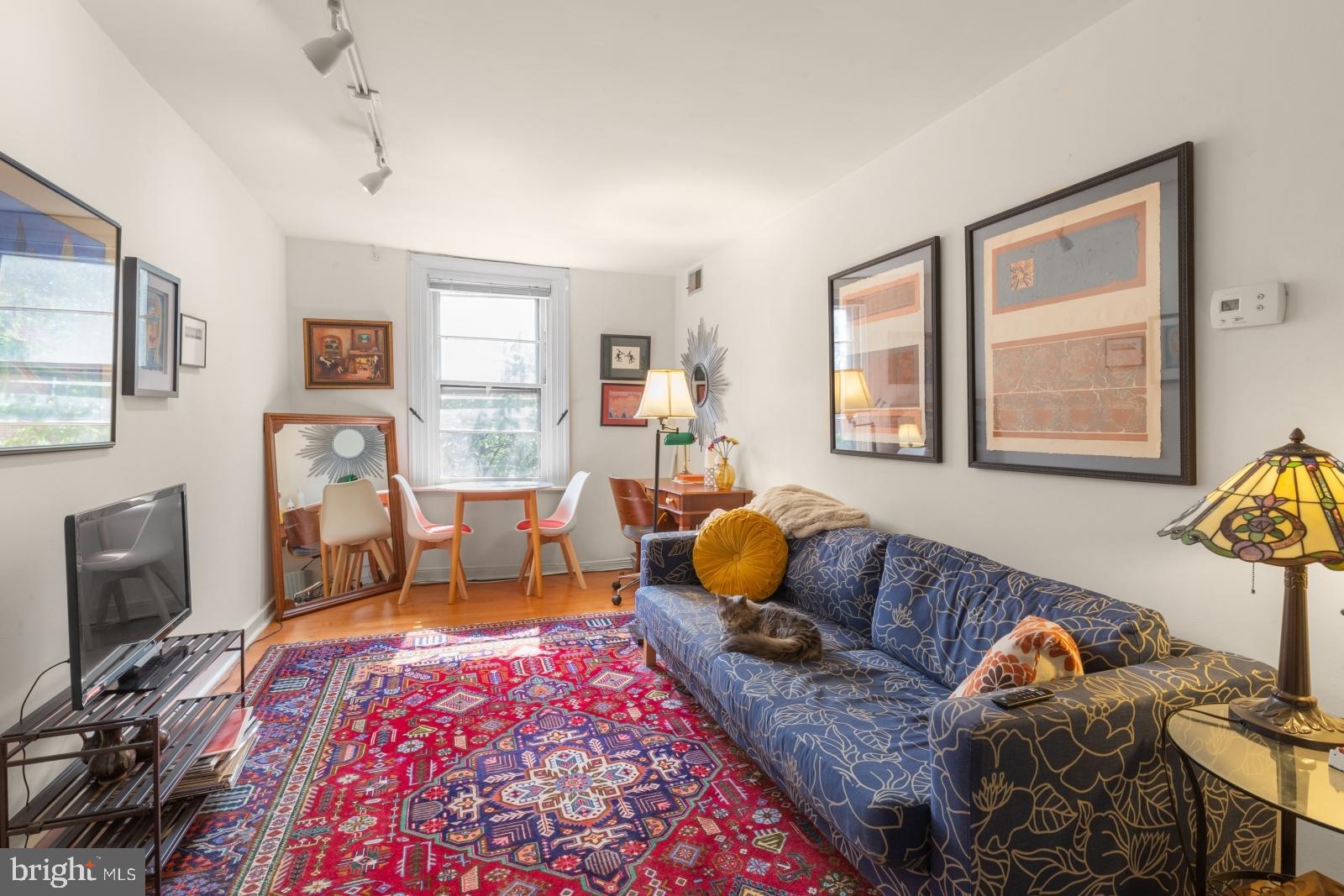 a living room with furniture and a flat screen tv with wooden floor