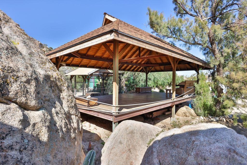 a backyard of a house with wooden floor and outdoor seating