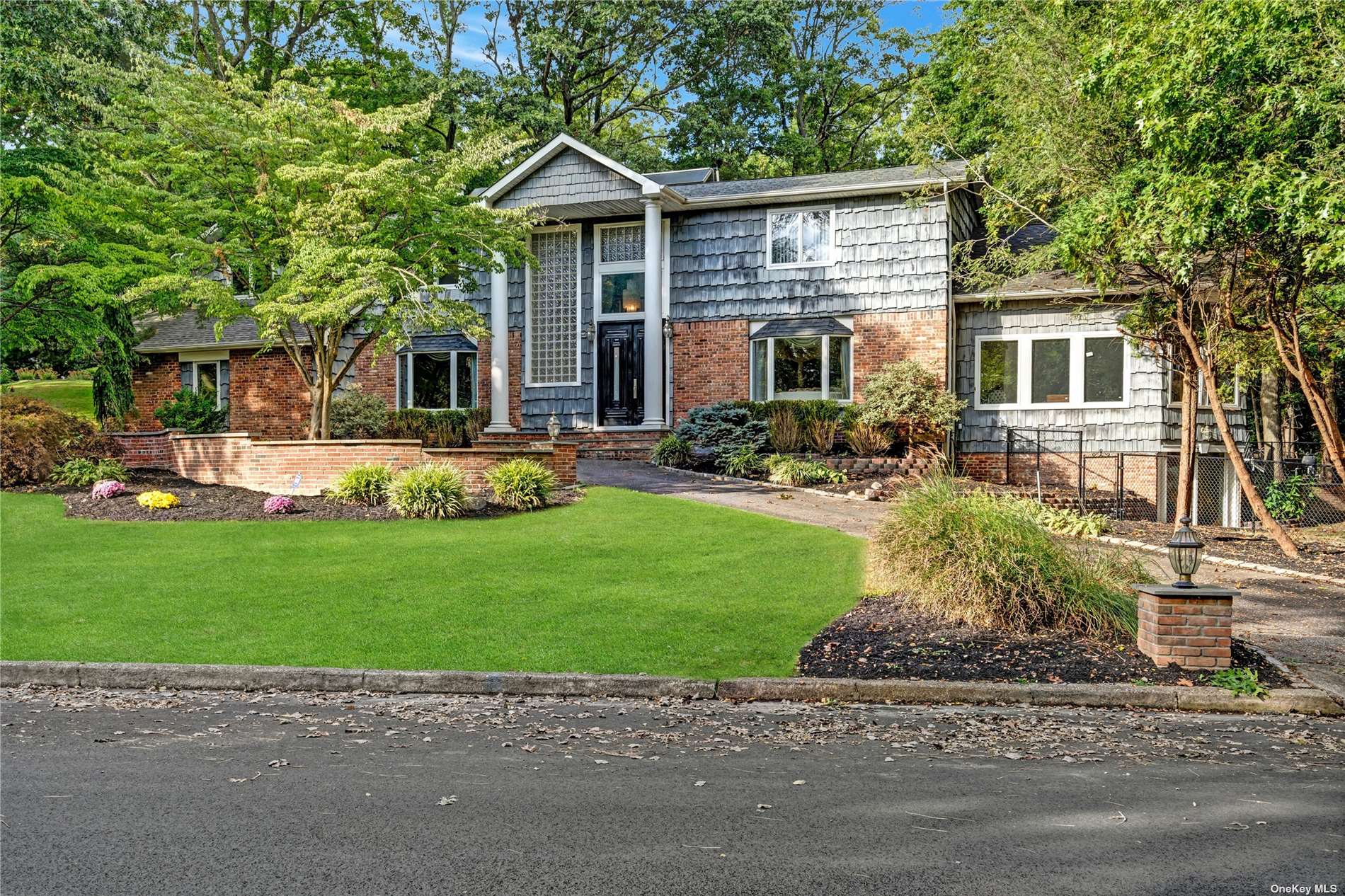 a front view of a house with a garden and yard