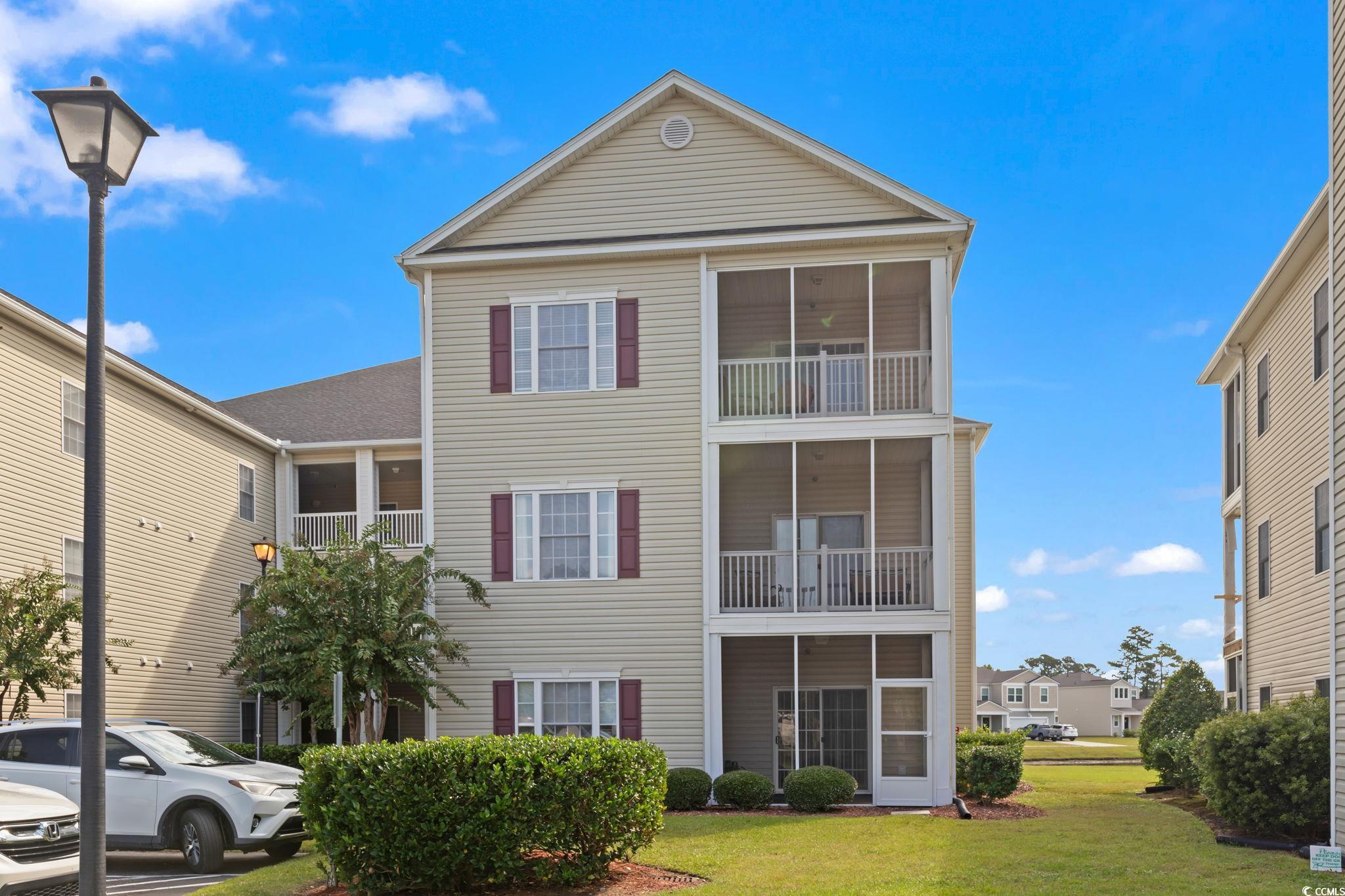 View of front of home with a front yard and a balc