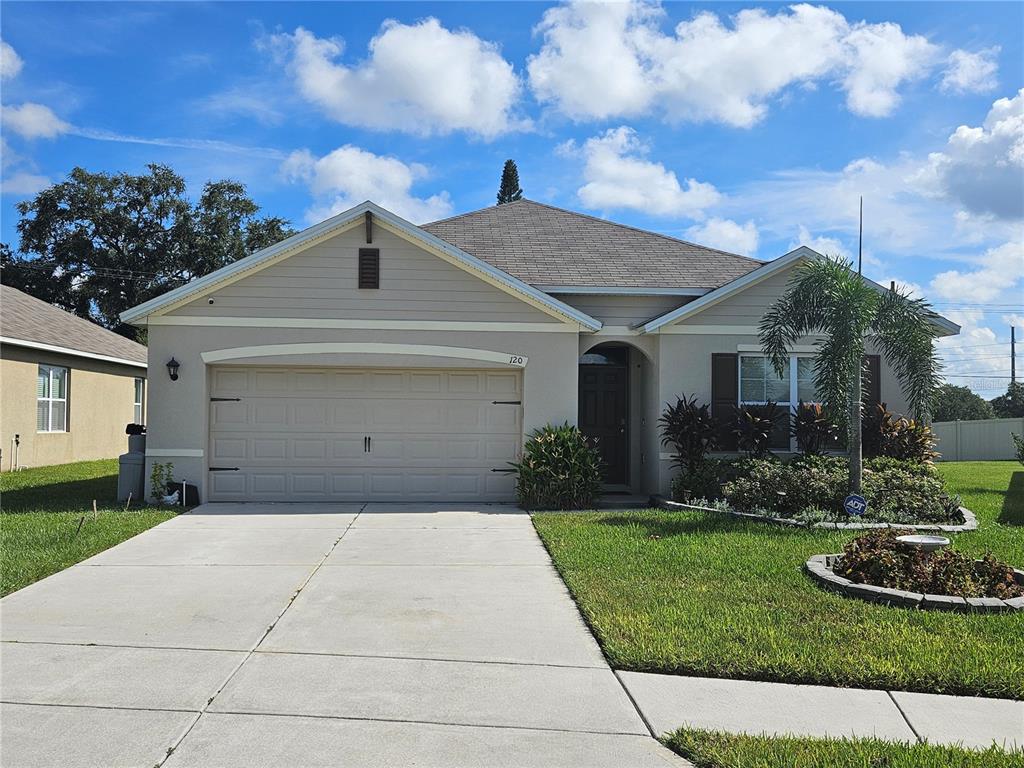 a front view of a house with a yard and garage